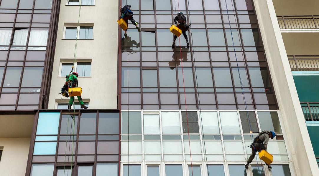 Traditional workers suspended at height for facade cleaning